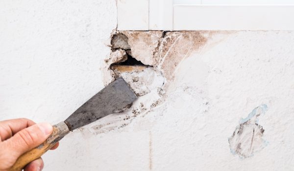Detail of the repair of a hole in the wall of the living room using filling mass.