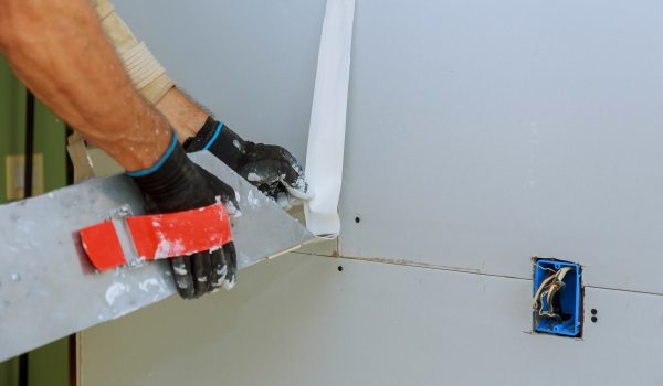 Worker plastering gypsum board wall apartment interior construction